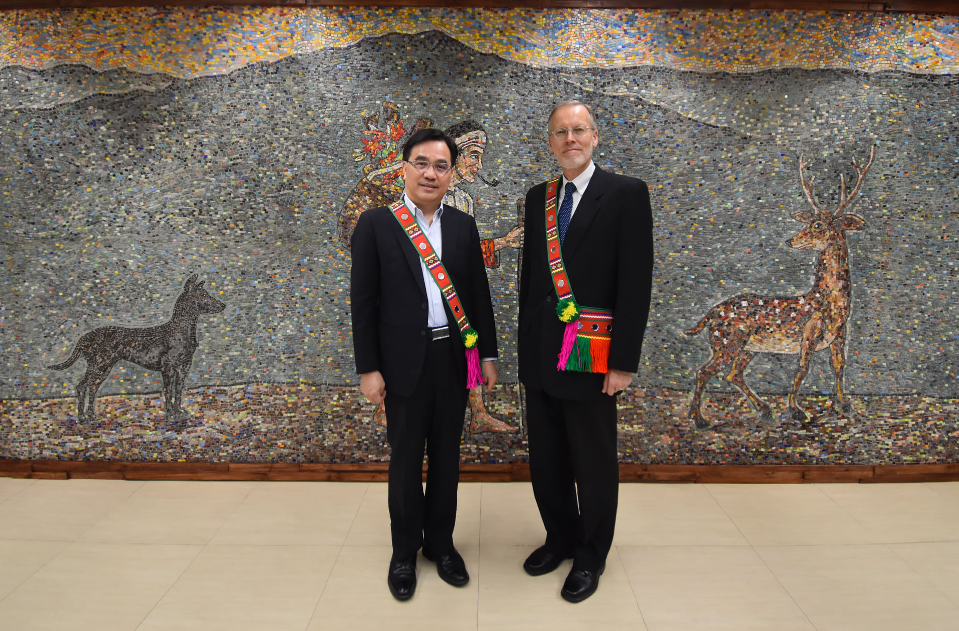 New Southbound Policy。CIP Minister Icyang Parod (left) and AIT Director Brent Christensen don traditional shoulder bags handcrafted by the Amis indigenous people before a meeting March 24 in New Taipei City. (Courtesy of CIP)