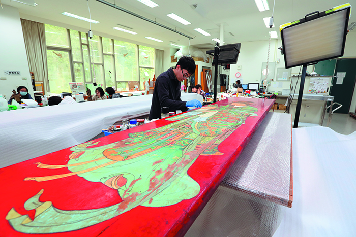 A student in the Graduate Institute of Conservation of Cultural Relics and Museology at Tainan National University of the Arts helps in a restoration project. (Photo by Chen Mei-ling)