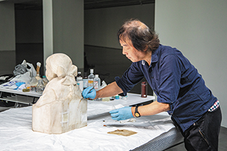 Girl by Huang Tu-shui undergoes restoration by Japanese expert Junichi Mori before an exhibition showcasing local art pioneers at National Taipei University of Education’s art museum. (Photo by Pang Chia-shan)