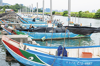 Fishing boats are moored along the Tamsui river bank. (Photo by Chen Mei-ling)