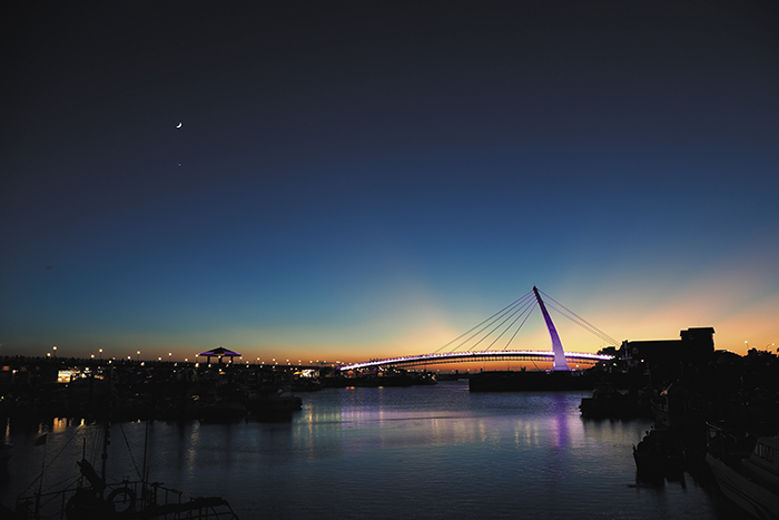 Lover’s Bridge lights up a riverside dusk. (Photo by Jimmy Lin)