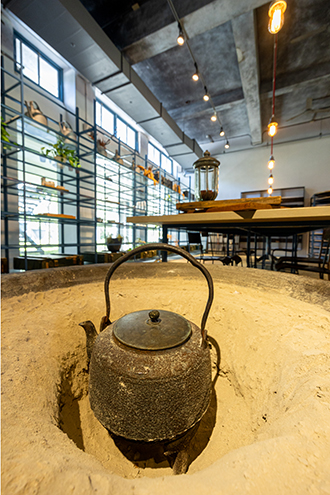 Sympathetic renovation retaining industrial design and combining it with modern minimalism is epitomized by the enduring feature of a large iron bowl filled with sand that historically kept a tea kettle warm for sending to wholesale customers. (Photo By Chen Mei-ling)