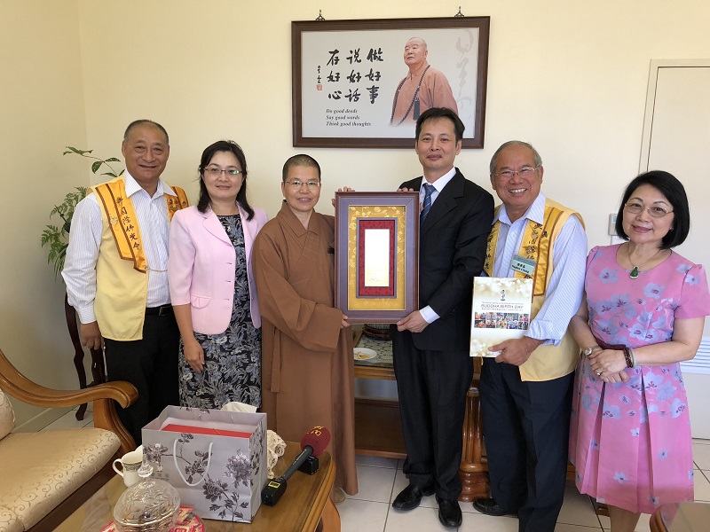 佛光山中天寺住持覺善法師致贈駐布里斯本辦事處洪振榮處長星雲大師一筆書法紀念牌匾（左起黃素珍僑務委員、張榮基會長、洪振榮處長、覺善法師、董幼文主任與張傳勝督導）