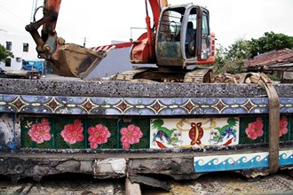 Rescuing roof-ridge decorative tiles from the grasp of a backhoe.  (courtesy of the Museum of Ancient Taiwan Tiles) 