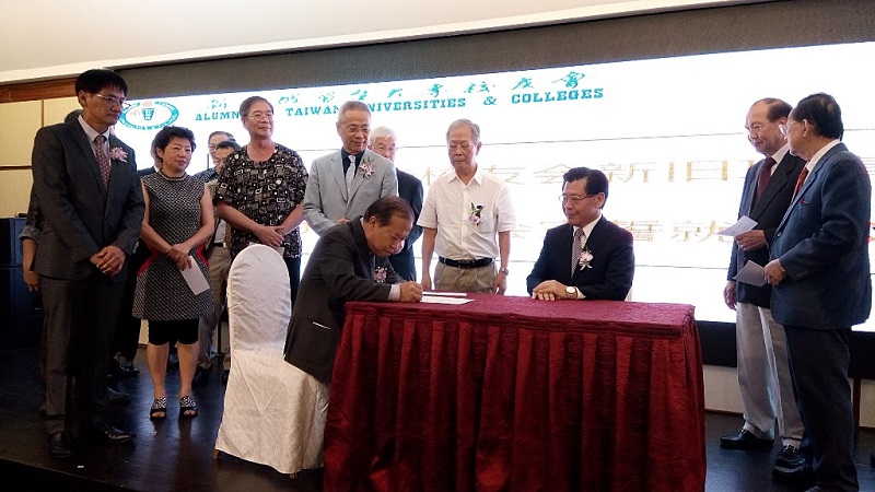 所有新任理事宣誓後現場簽字，由梁代表(坐者右)見證，圖為新任秘書長潘廣齋正完成簽字。