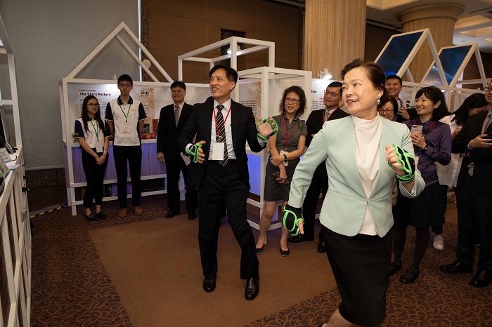 MOEA Deputy Minister Wang Mei-hua (front, right) tries an innovative product displayed at the SMEA-hosted APEC Local Innovation Ecosystem Forum June 24 in Taipei City. (Courtesy of MOEA)