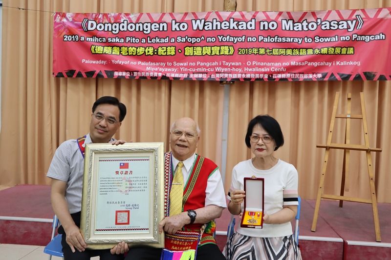 Ngày 5/8, Chủ nhiệm Ủy ban Dân tộc nguyên trú Icyang Parod (bên trái) đã trao tặng Huân chương Dân tộc nguyên trú hạng nhất cho học giả dân tộc Amis Ngô Minh Nghĩa (ngồi giữa) nhằm biểu dương những đóng góp của ông trong công tác bảo tồn ngôn ngữ, văn hóa, giáo dục và phát triển học thuật của dân tộc Amis. Người ngồi bên phải là vợ ông Ngô Minh Nghĩa (Ảnh: CNA)