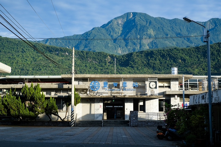 Fengtian Train Station in the early morning: The sun is rising on a tranquil scene, ringed by mountains.