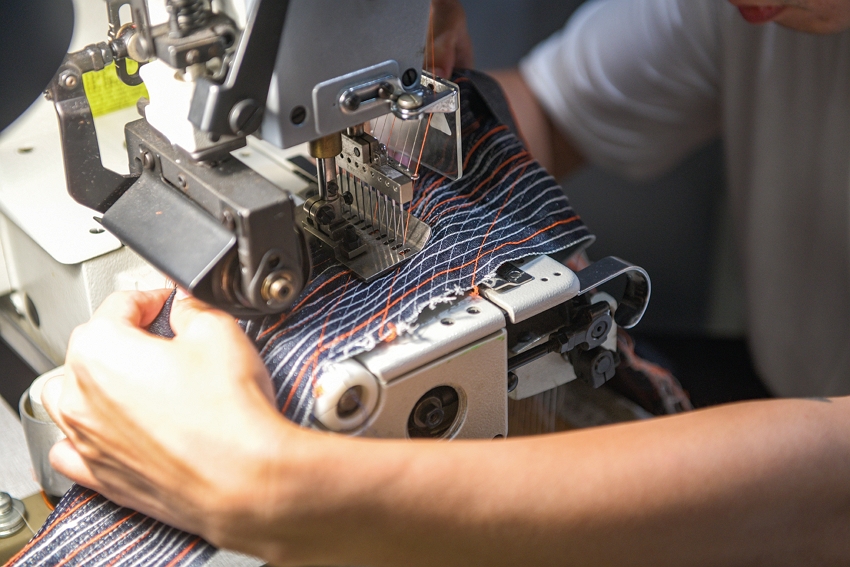 This kind of 12-needle sewing machine is usually used to stitch elastic. Here, a designer is using one to sew different stitches in a variety of colors to create a decorative pattern on clothing.