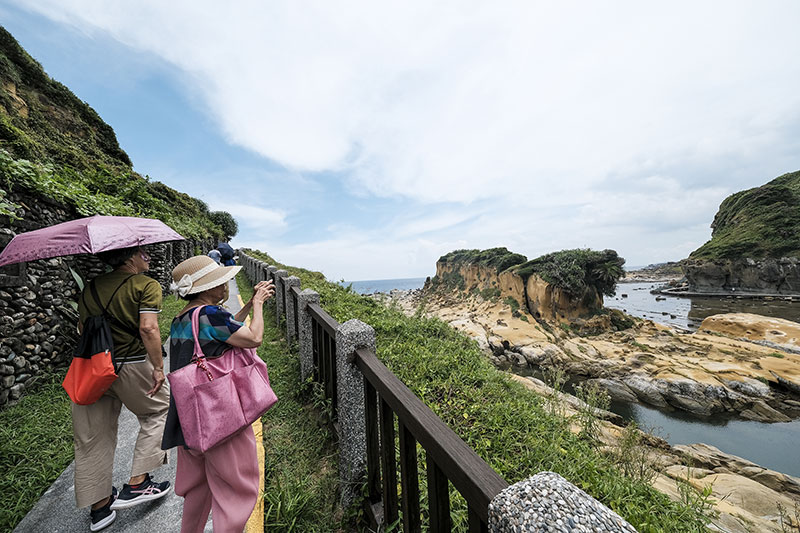 Visitors admire the extraordinary landforms along the coastal path.