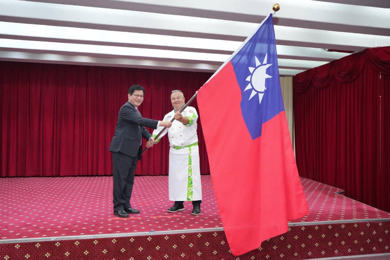 外交部長林佳龍授旗給代表隊駱進漢總領隊並為代表隊加油打氣。