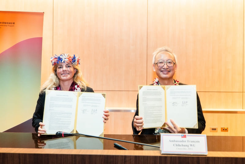 Deputy Foreign Minister François Chih-chung Wu (right) is joined by Celeste Connors, president of Hawaii-based East-West Center, in displaying the renewed five-year memorandum of understanding at the closing ceremony of the 10th Pacific Islands Leadership Program with Taiwan Sept. 17 in Taipei City. (MOFA)