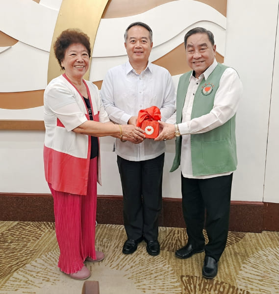 在周大使（中）的見證下，滿任周鄭貴玉董事長（左）將印信交予新任謝國萬董事長（右）